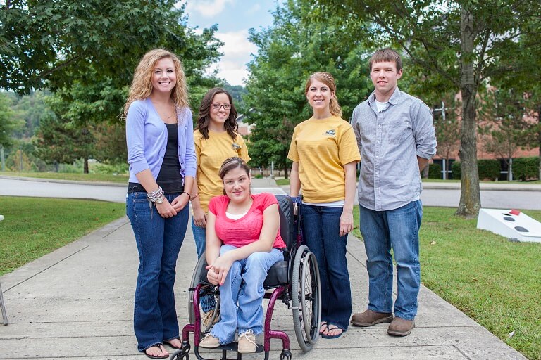 Four students posing with a student in a wheelchair