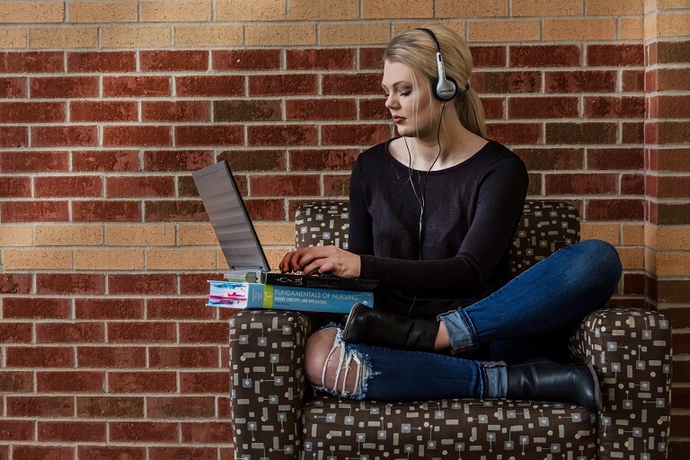 person of color women on couch with computer